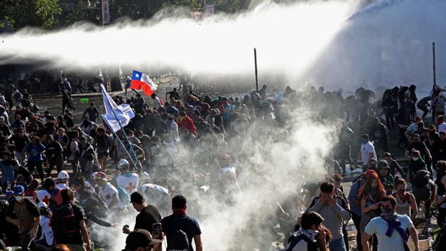 Las fuerzas de seguridad lanzan agua y gases lacrimógenos en Santiago de Chile, el 20 de octubre de 2019.